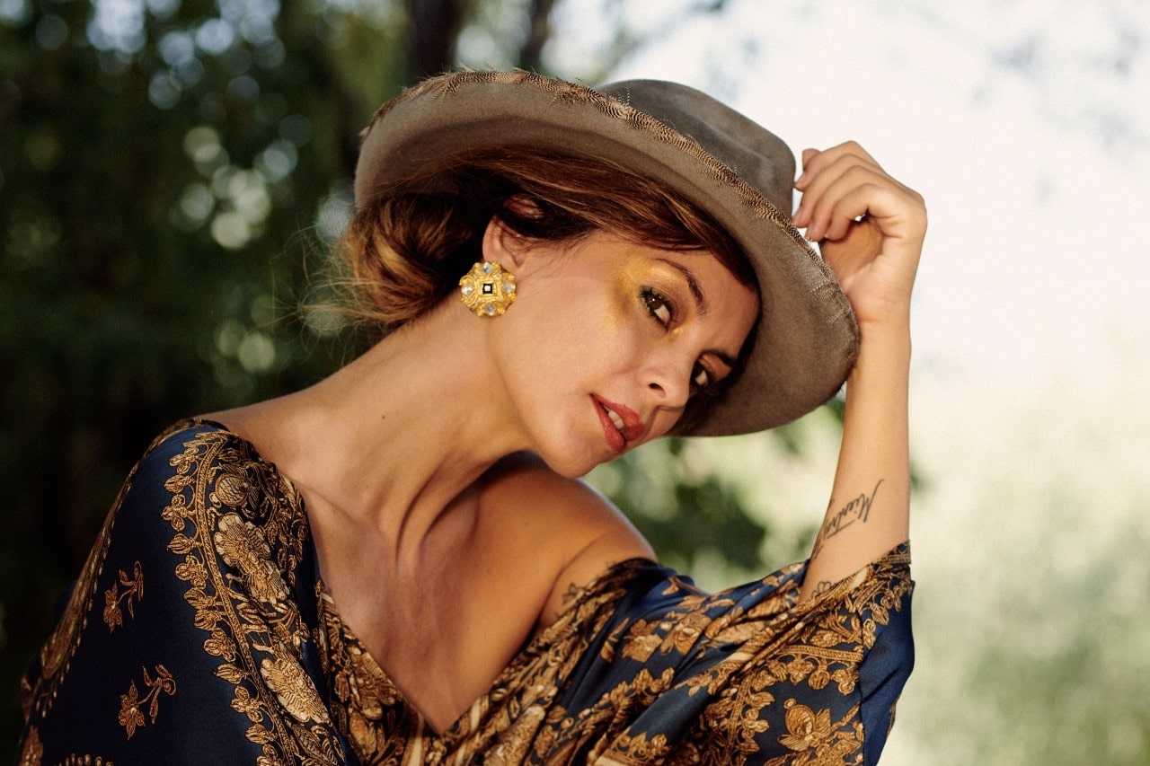 A shot of an elegantly dressed woman wearing bold gold earrings. A shot of an elegantly dressed woman wearing bold gold earrings.