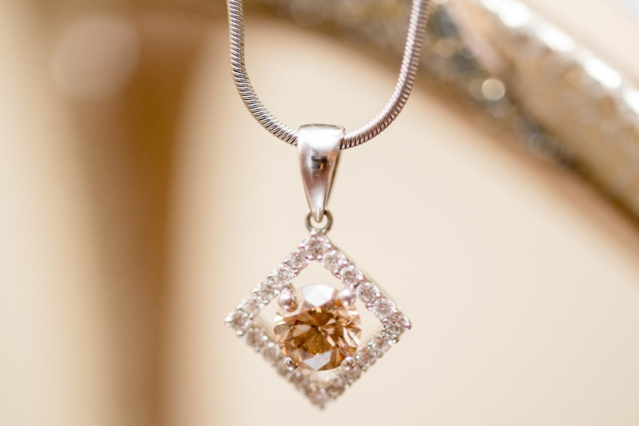 A close-up of a stunning gold pendant necklace with a distinctive center stone. A close-up of a stunning gold pendant necklace with a distinctive center stone.