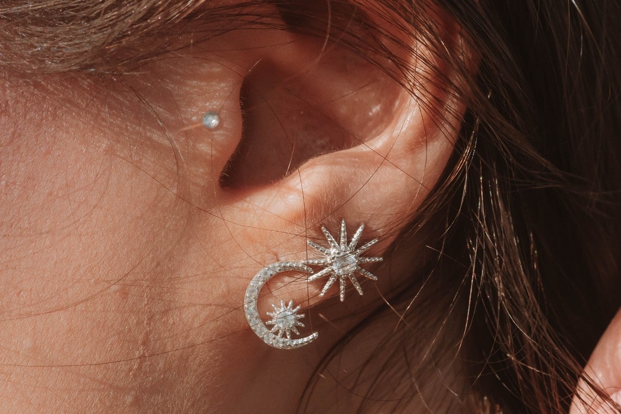 A close-up image of a woman’s heart adorned with three diamond stud earrings. A close-up image of a woman’s heart adorned with three diamond stud earrings.