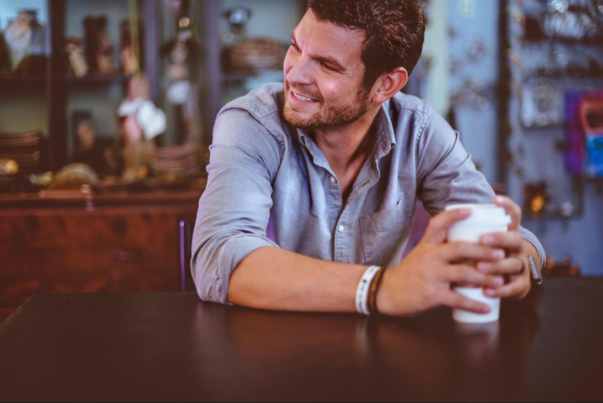 A close-up of a man drinking coffee, wearing fashionable bracelets. A close-up of a man drinking coffee, wearing fashionable bracelets.